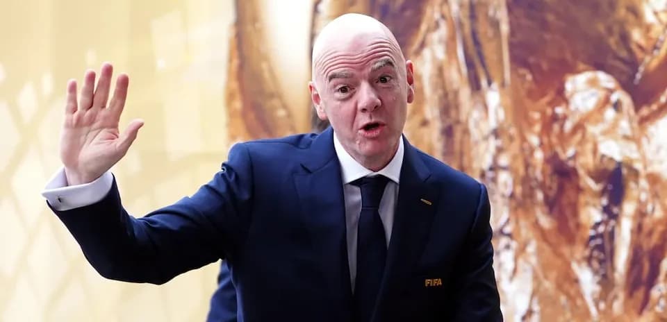 Homme en costume saluant lors d'un événement FIFA