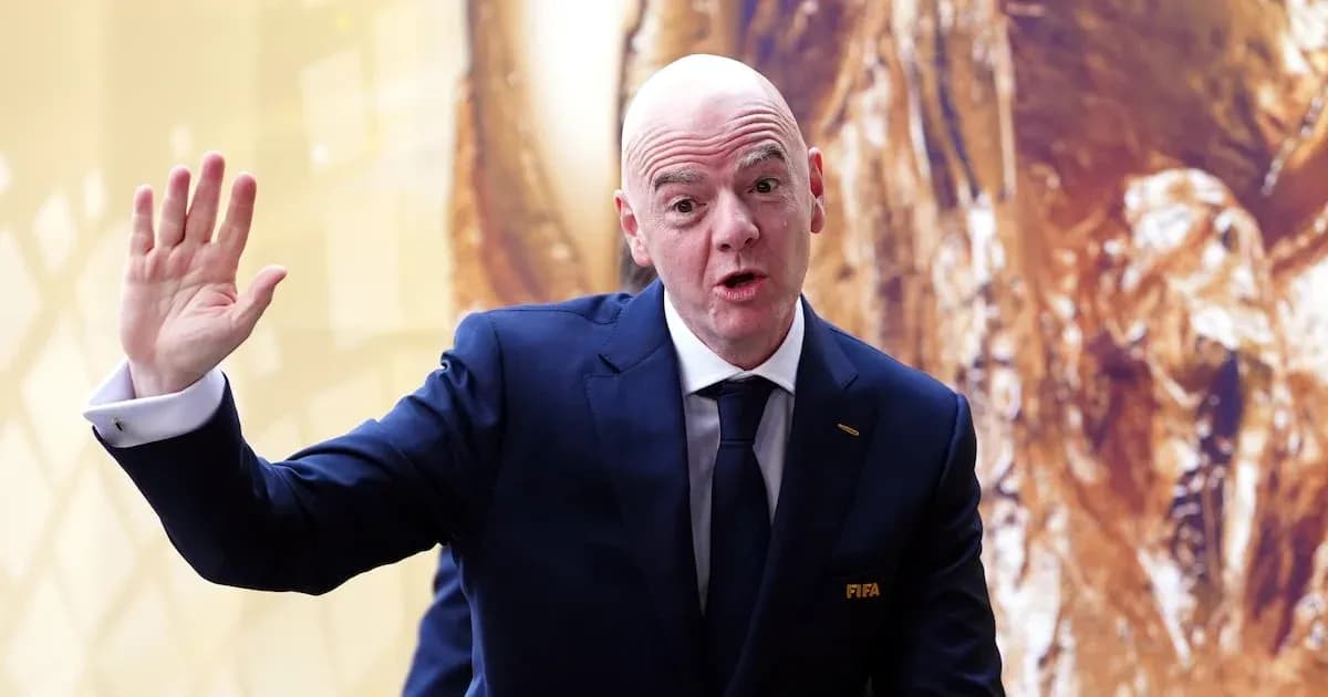 Homme en costume saluant lors d'un événement FIFA