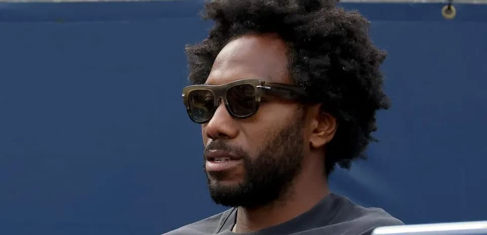 Homme portant des lunettes de soleil, assis sur un banc