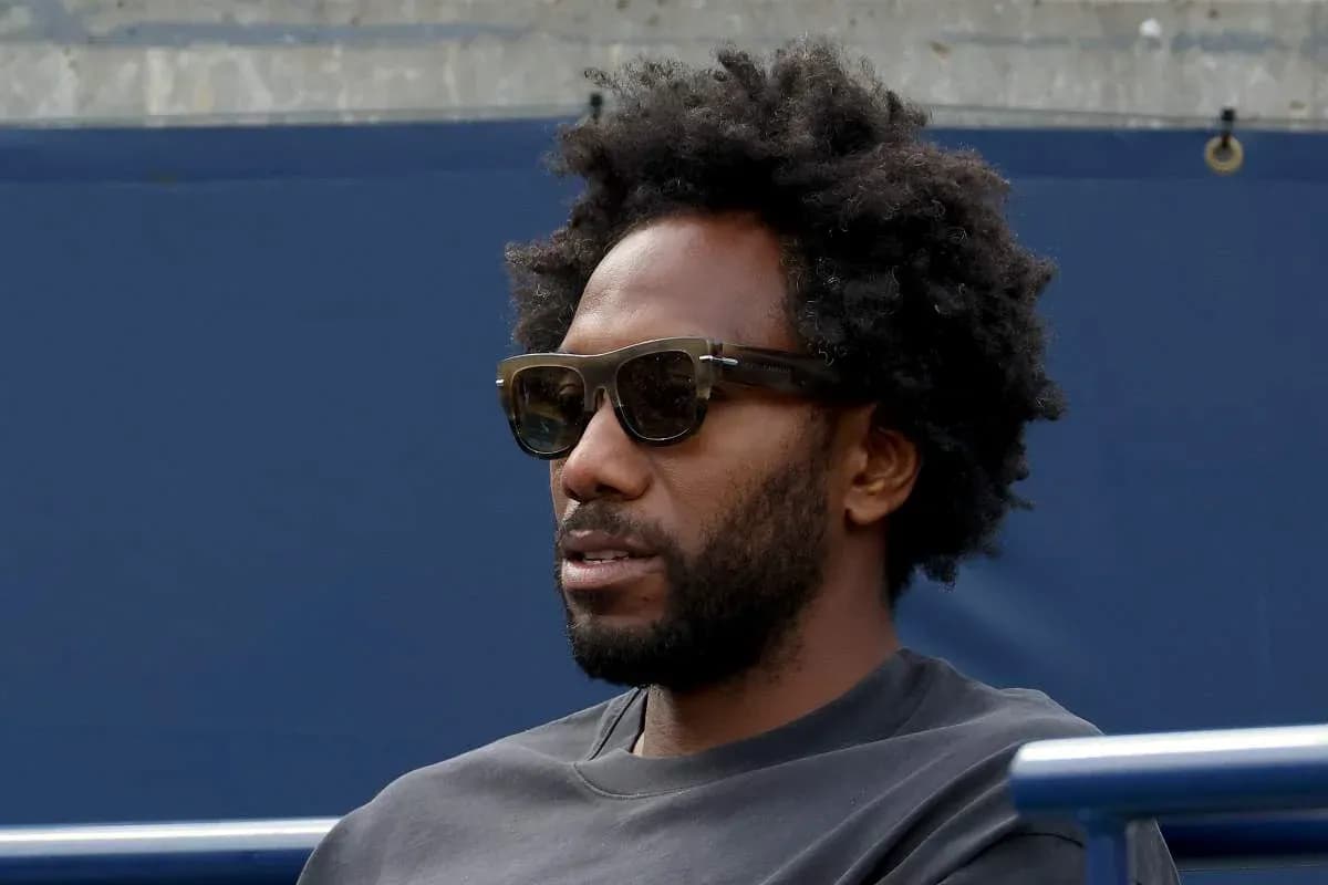 Homme portant des lunettes de soleil, assis sur un banc