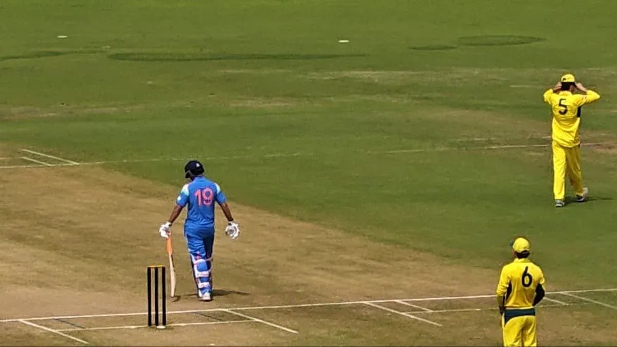 Batsman in blue uniform walking to the crease