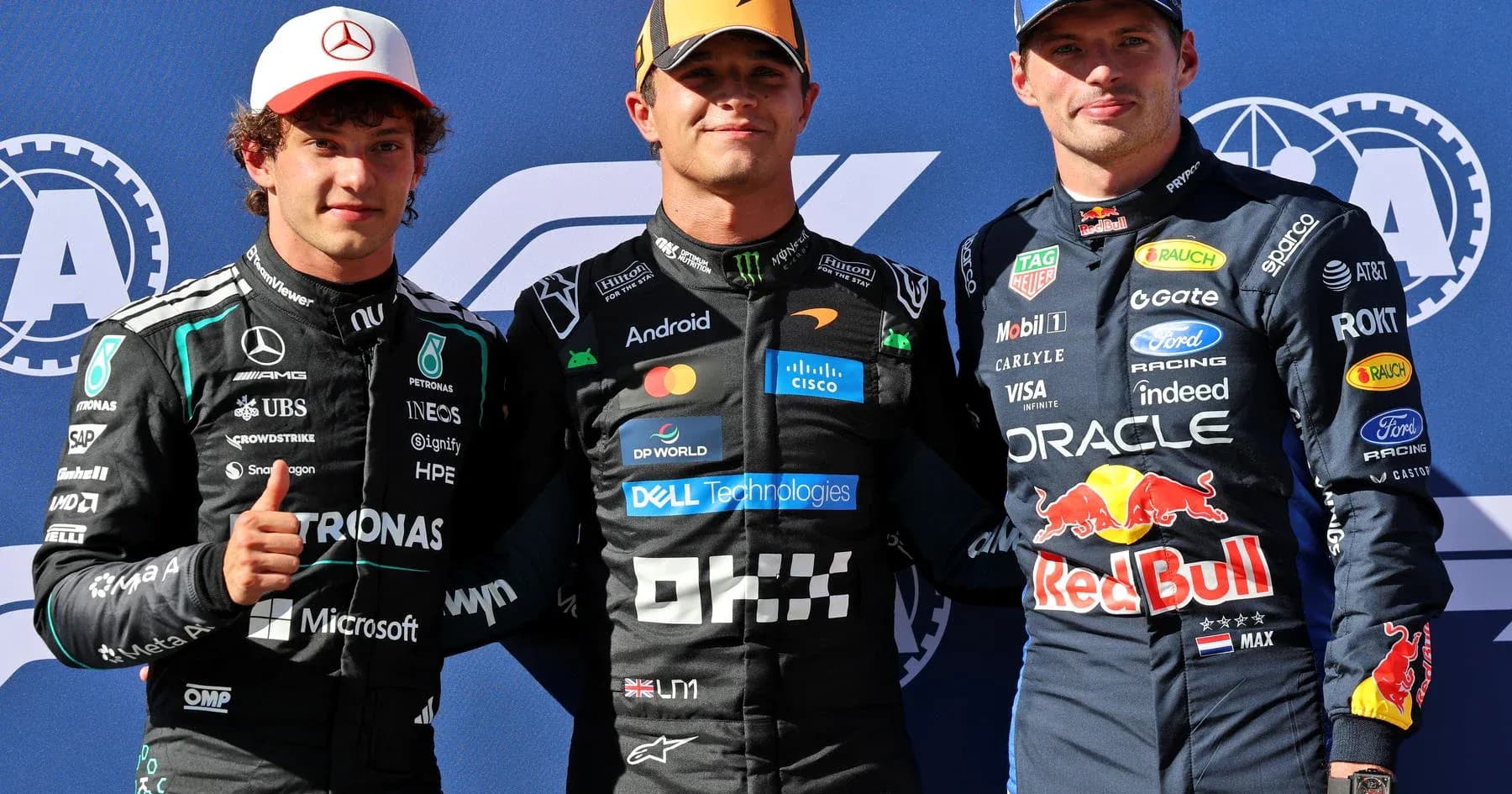 Trois pilotes de F1 posant sur le podium
