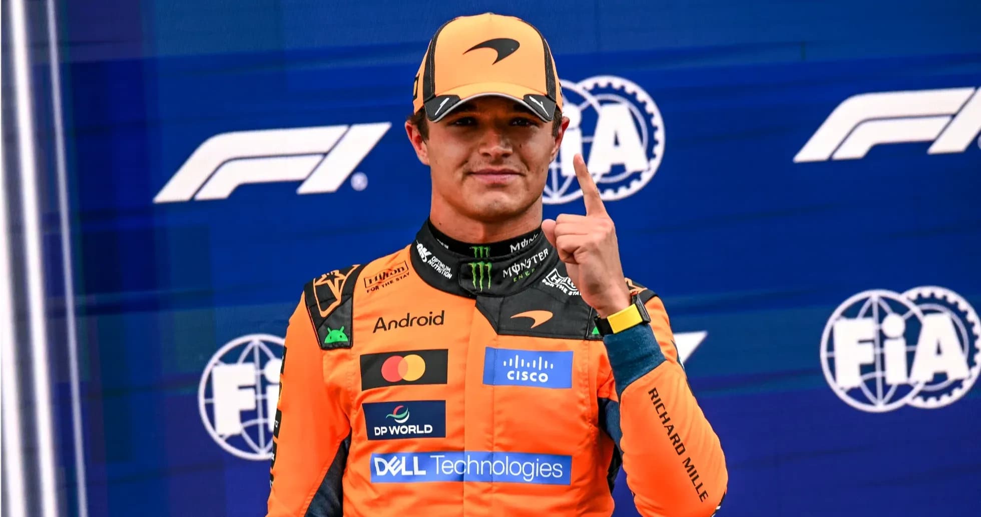 Pilote posant avec un doigt levé sur podium