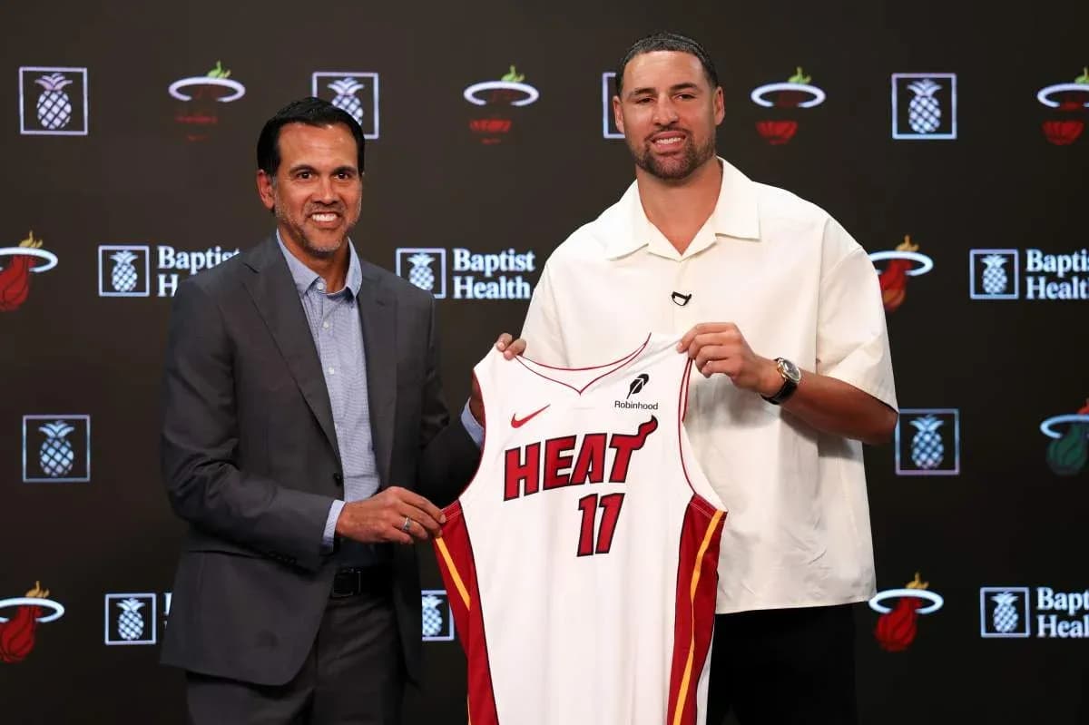 Entraîneur et joueur présentant le maillot des Heat