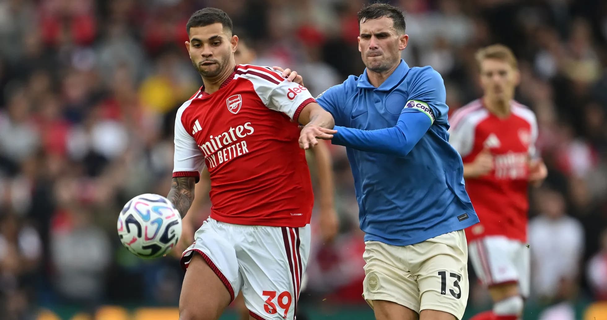 Joueur d'Arsenal dribblant sous la pression d'un adversaire