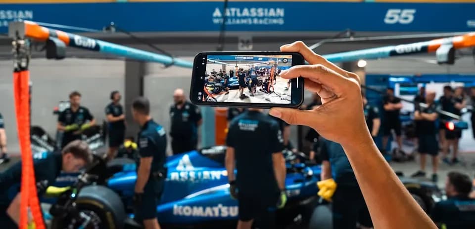 Person prenant une photo dans un garage de F1
