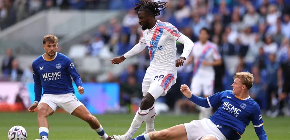Joueur de Crystal Palace dribblant deux adversaires d'Everton