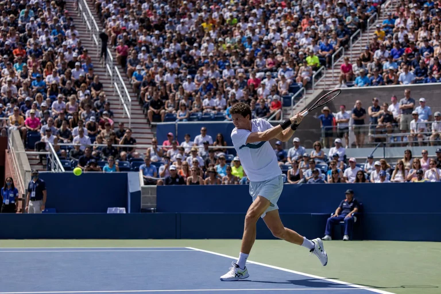 Joueur de tennis frappant une balle devant un public