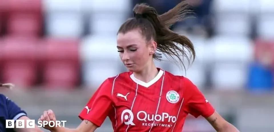 Joueuse en maillot rouge dribblant sur le terrain