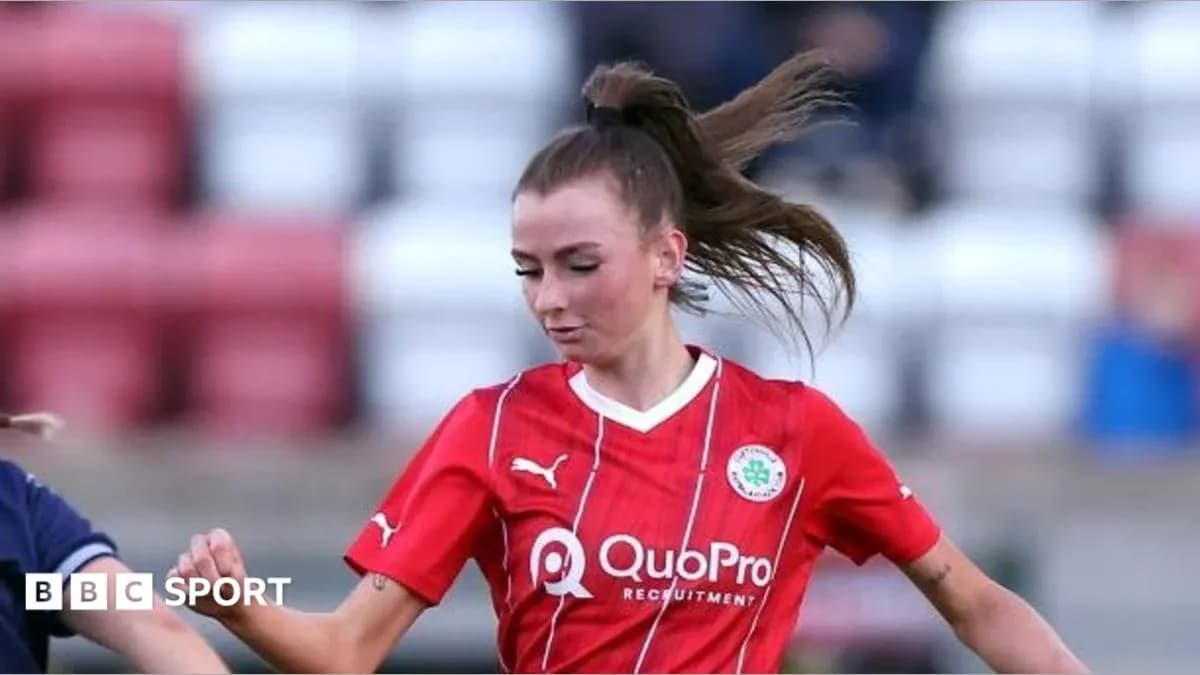 Joueuse en maillot rouge dribblant sur le terrain