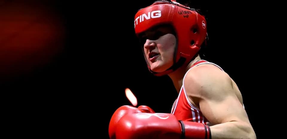 Boxeuse avec casque et gants rouges en action