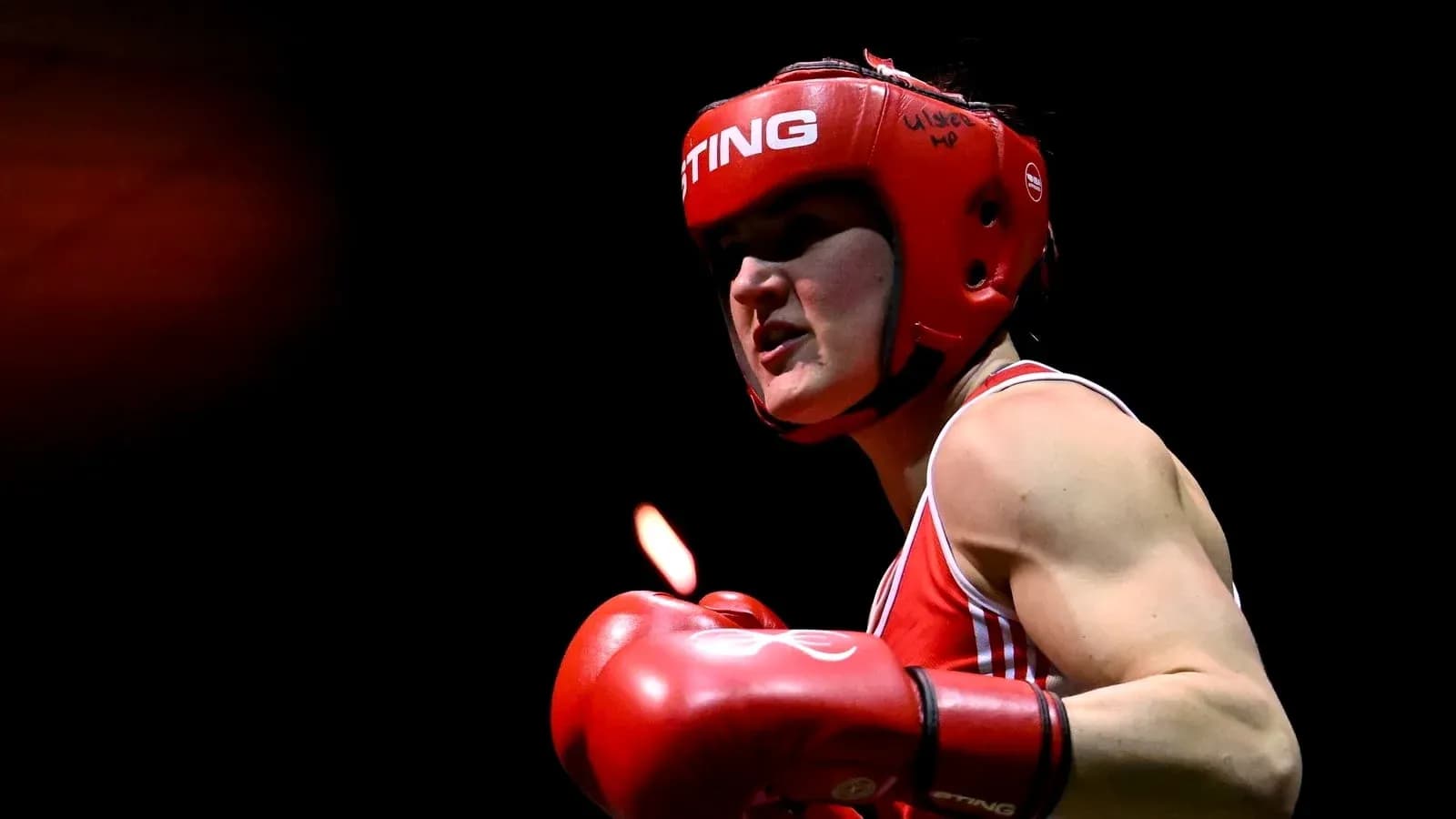 Boxeuse avec casque et gants rouges en action