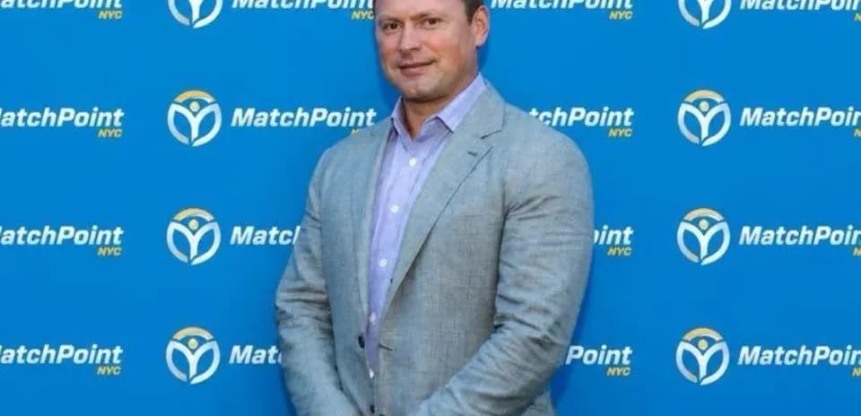 Homme posant devant un fond MatchPoint NYC