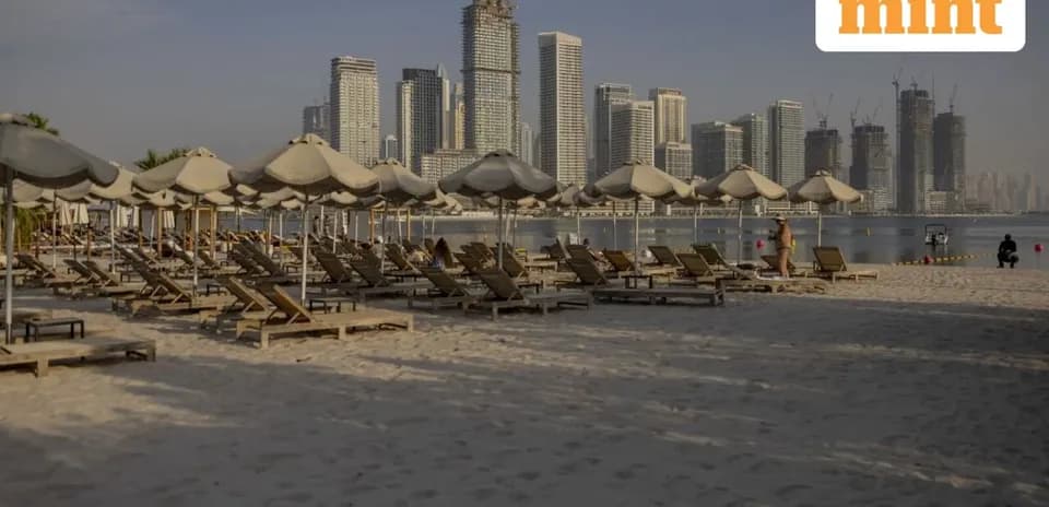 Plage avec chaises longues et immeubles en arrière-plan