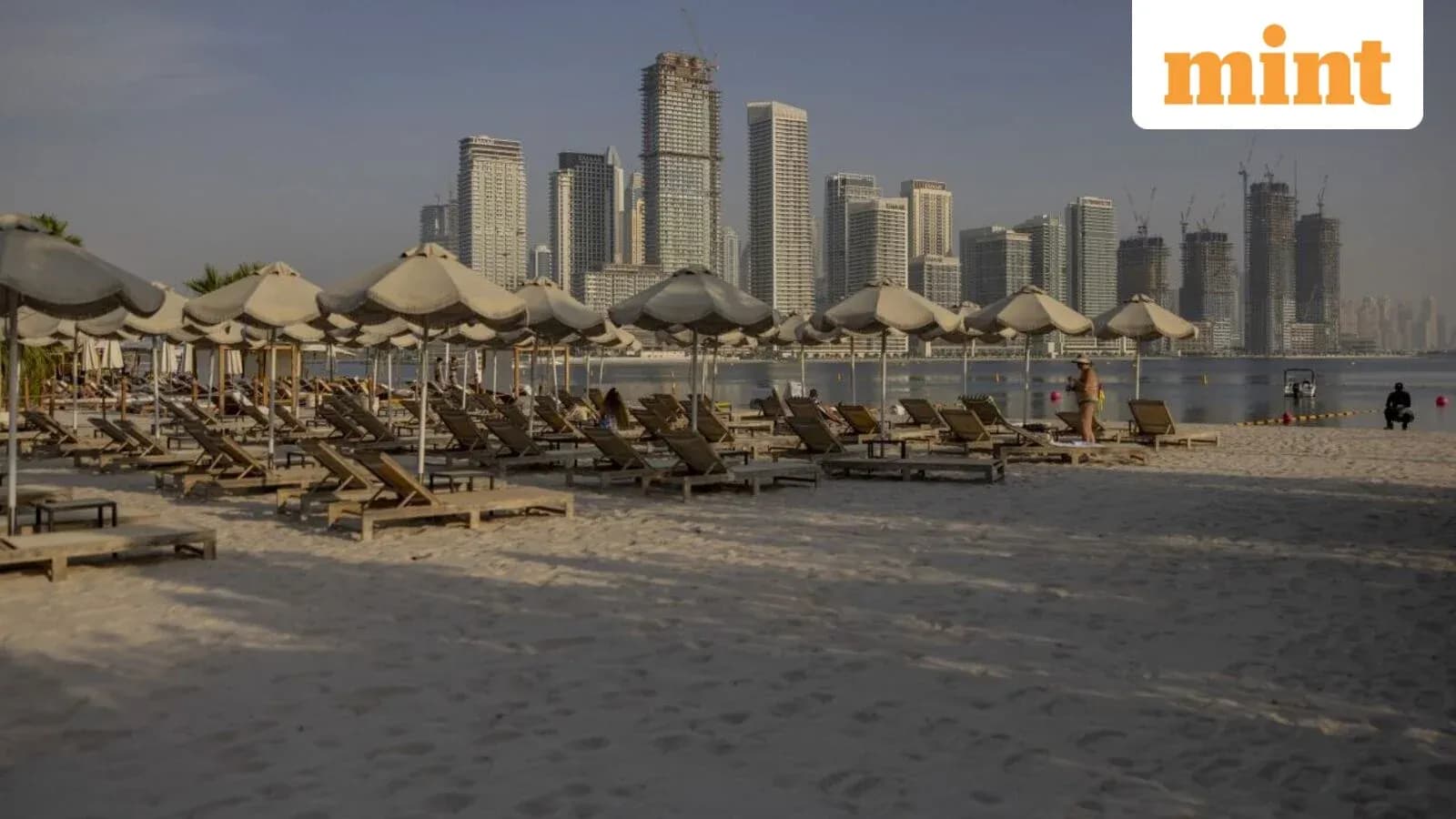 Plage avec chaises longues et immeubles en arrière-plan