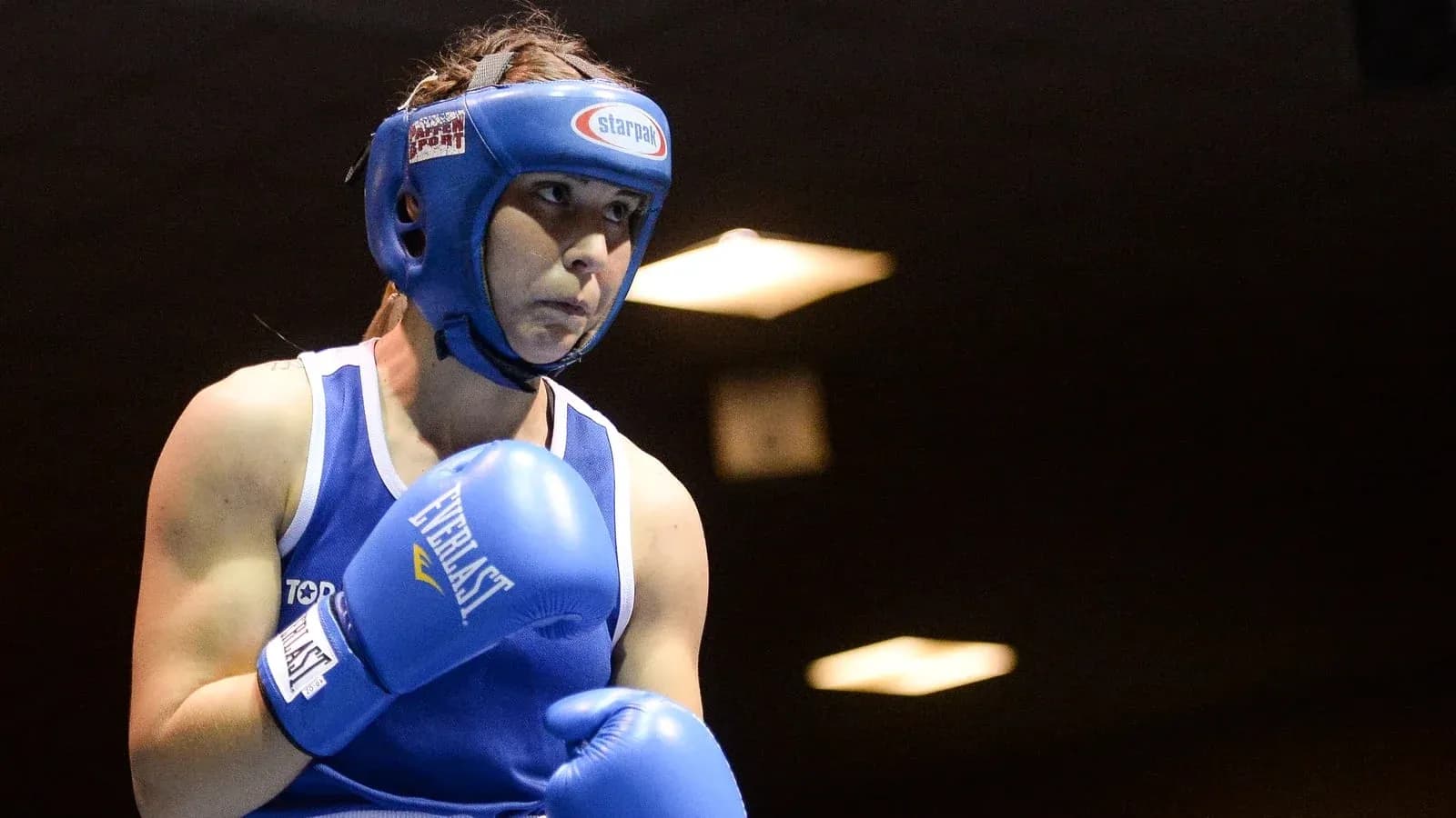 Boxeuse en action avec gants bleus sur le ring