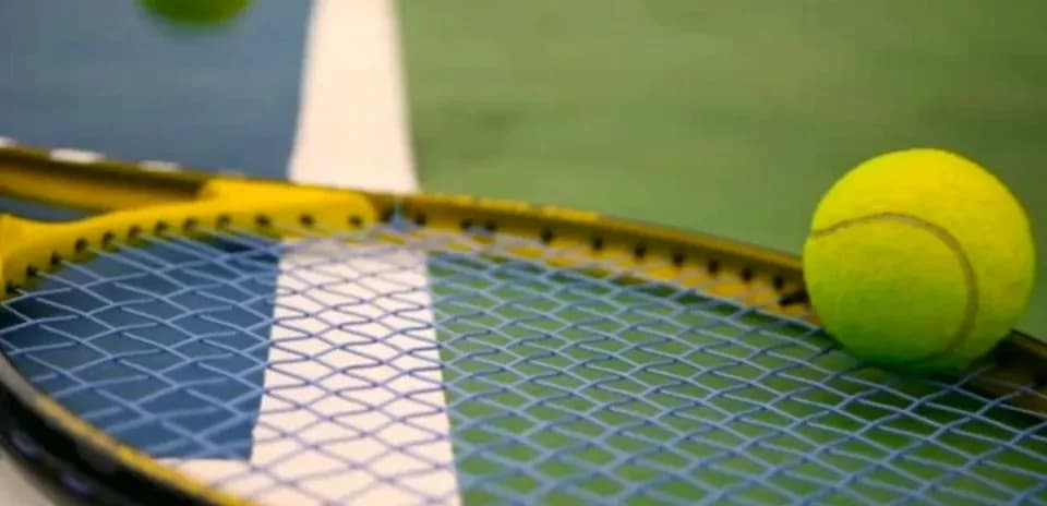 Balle de tennis sur une raquette sur terrain