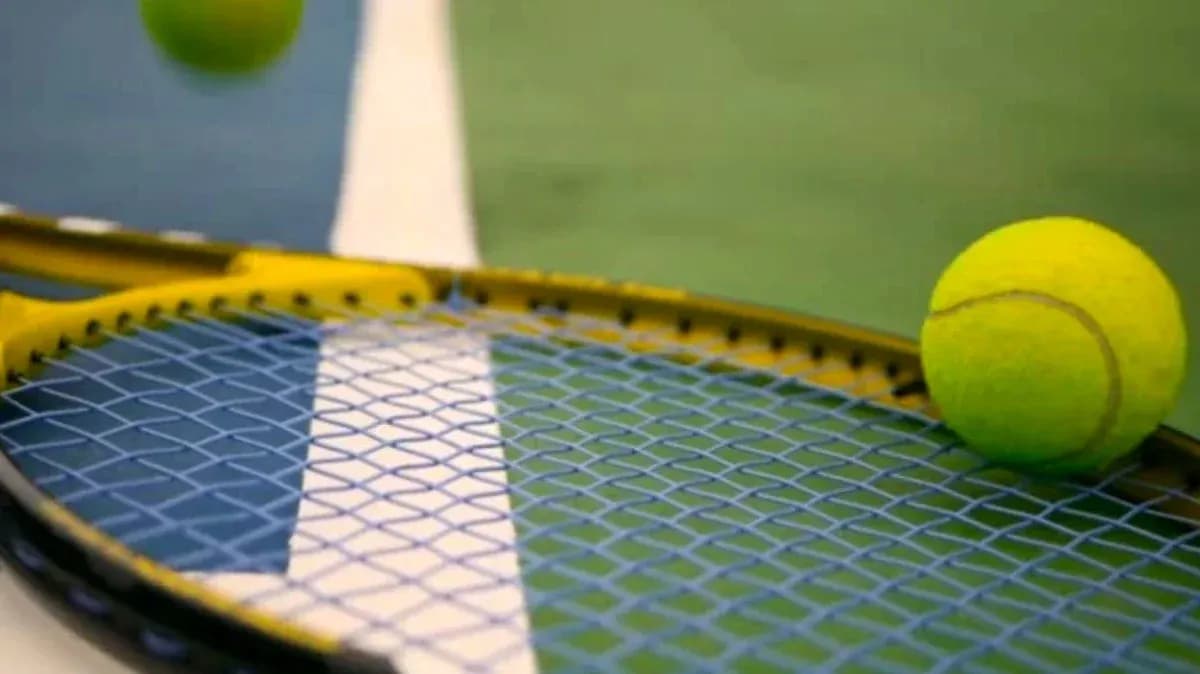Balle de tennis sur une raquette sur terrain