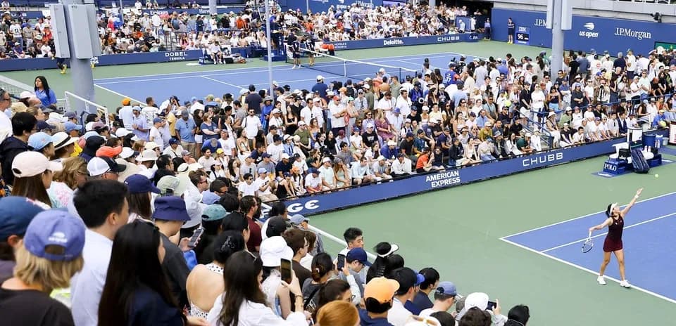 Joueuse servant devant un public nombreux au tennis