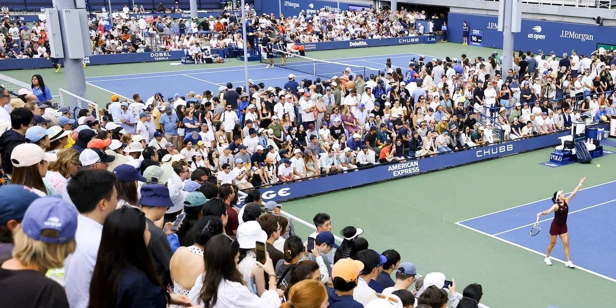 Joueuse servant devant un public nombreux au tennis