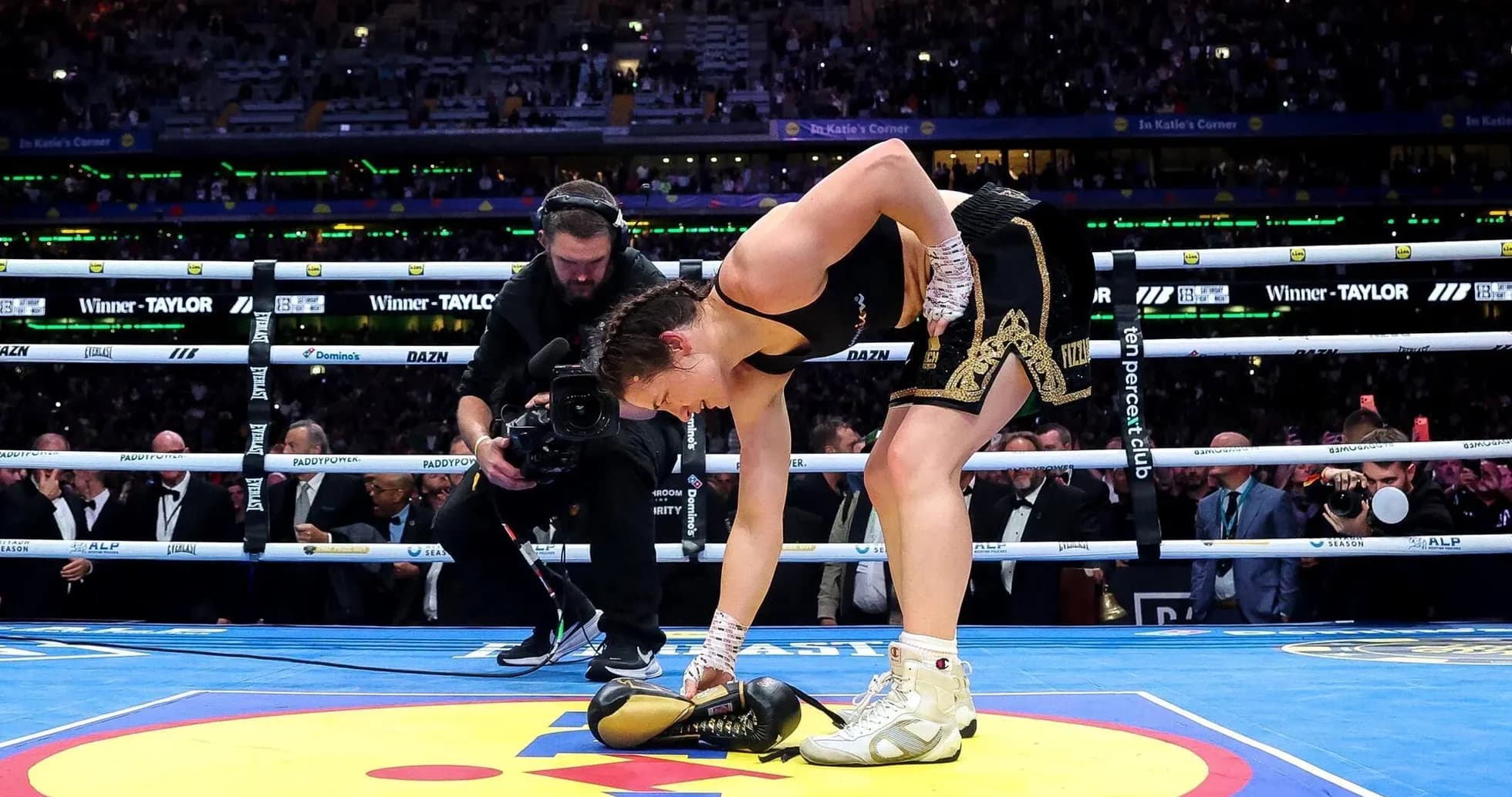 Boxeuse ramassant des gants sur le ring
