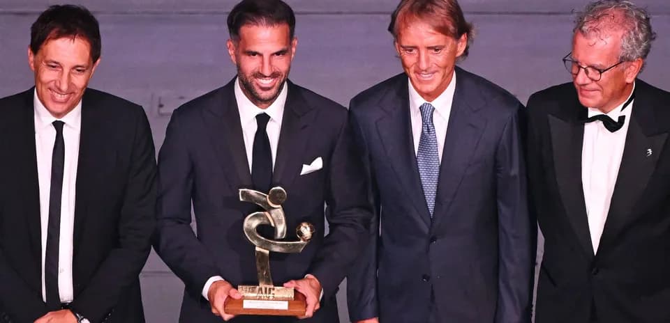 Quatre hommes posant avec un trophée lors d'une cérémonie