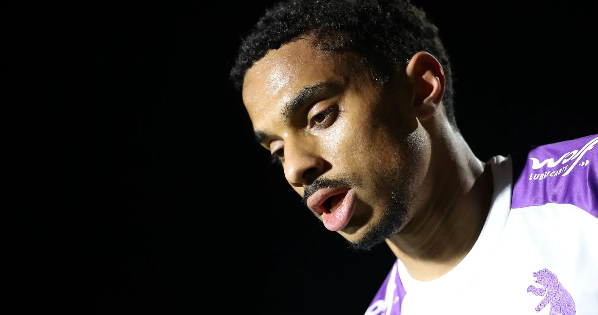 Joueur de football en gros plan sur fond sombre