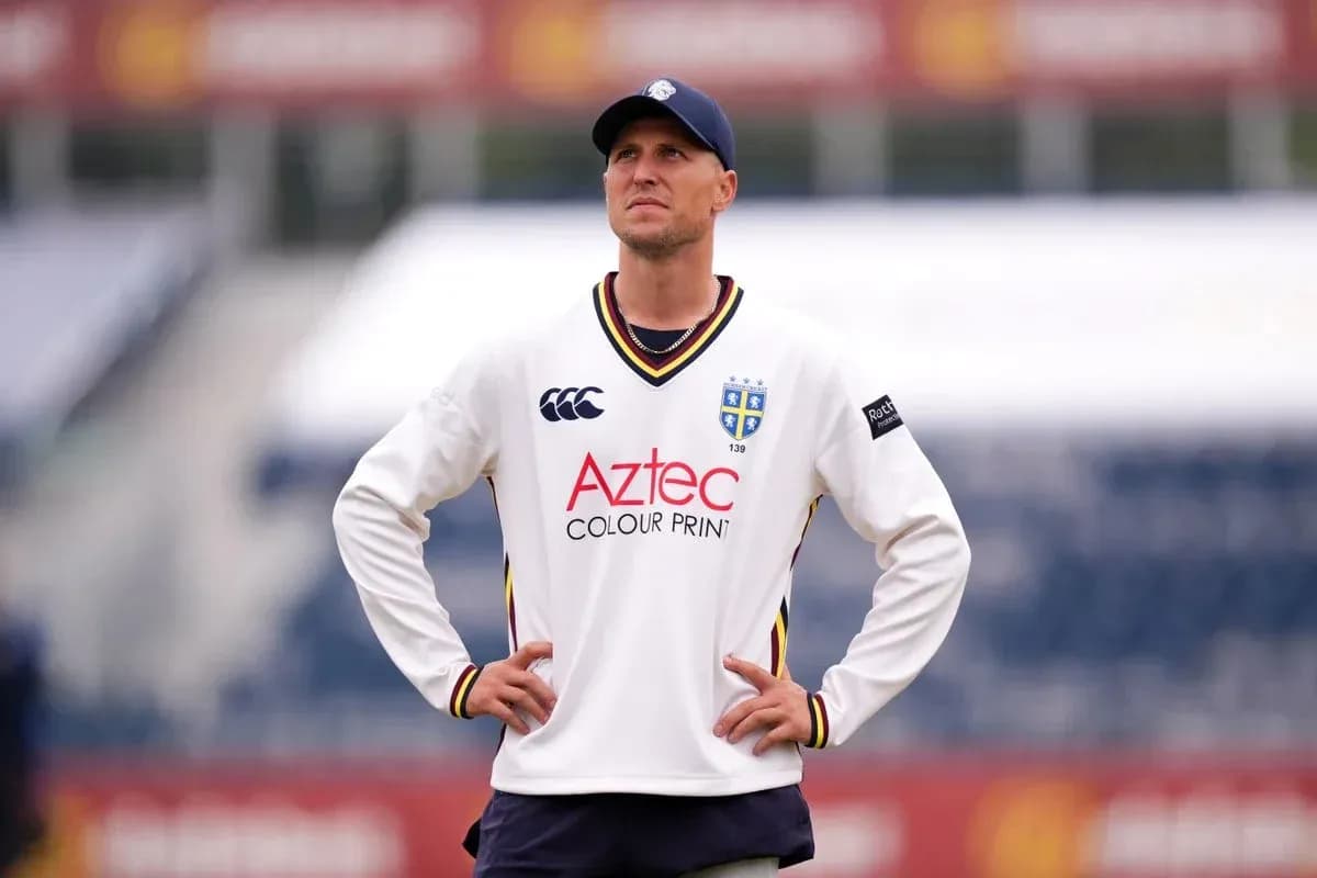 Joueur de cricket en tenue regardant le terrain