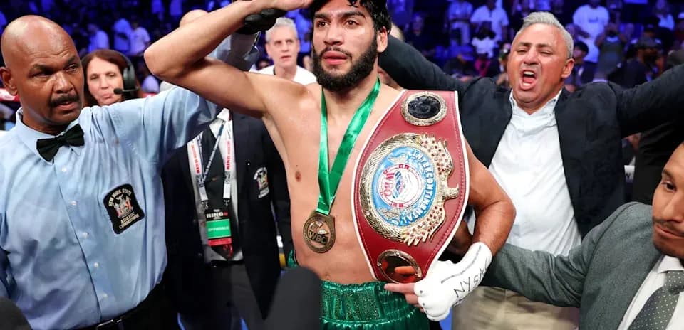 Boxeur célébrant avec ceinture après victoire de match