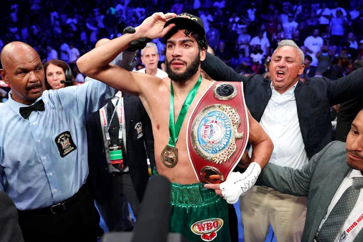 Boxeur célébrant avec ceinture après victoire de match