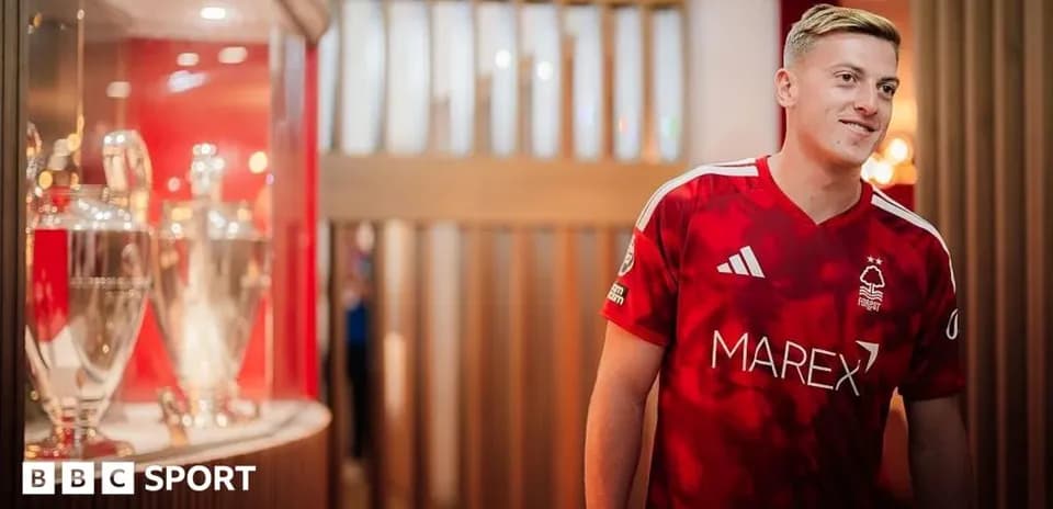 Joueur en maillot rouge près de trophées