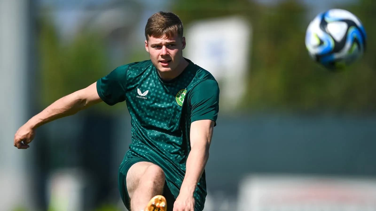 Joueur s'entraînant en tirant sur un ballon de football Joueur s'entraînant en tirant sur un ballon de football
