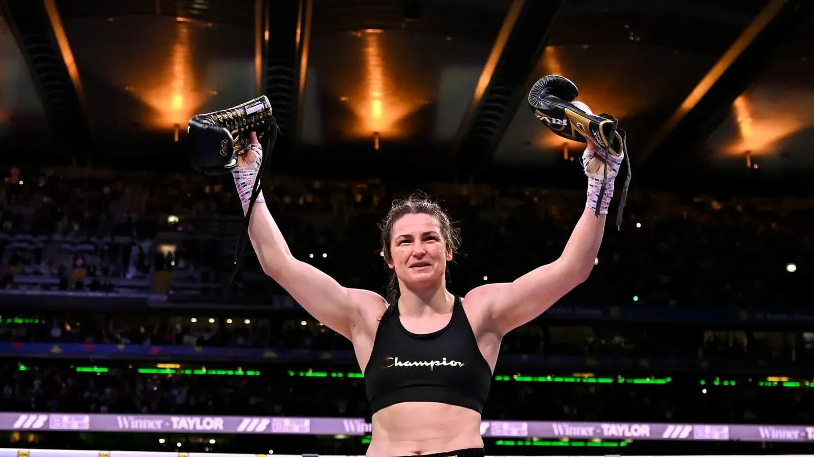 Boxeuse célébrant avec des gants levés après victoire Boxeuse célébrant avec des gants levés après victoire