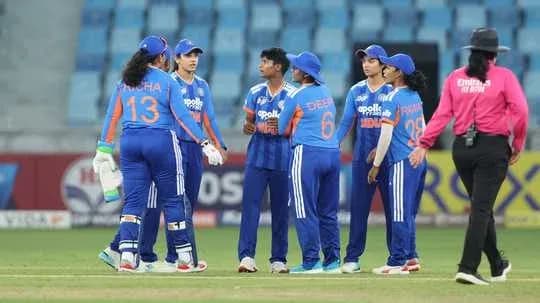 Équipe féminine de cricket discutant sur le terrain Équipe féminine de cricket discutant sur le terrain