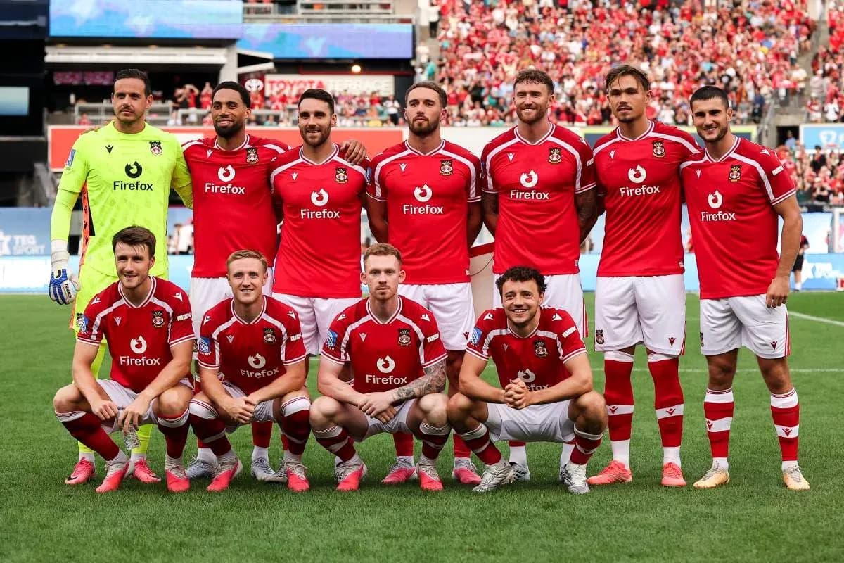 Équipe de football posant en maillots rouges Équipe de football posant en maillots rouges