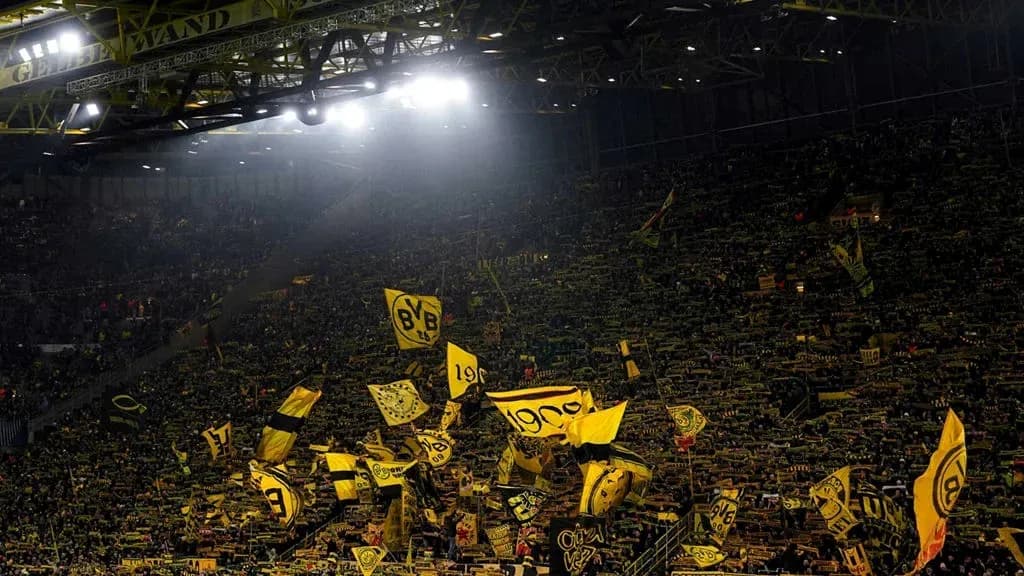 Supporters waving flags in a packed stadium Supporters waving flags in a packed stadium