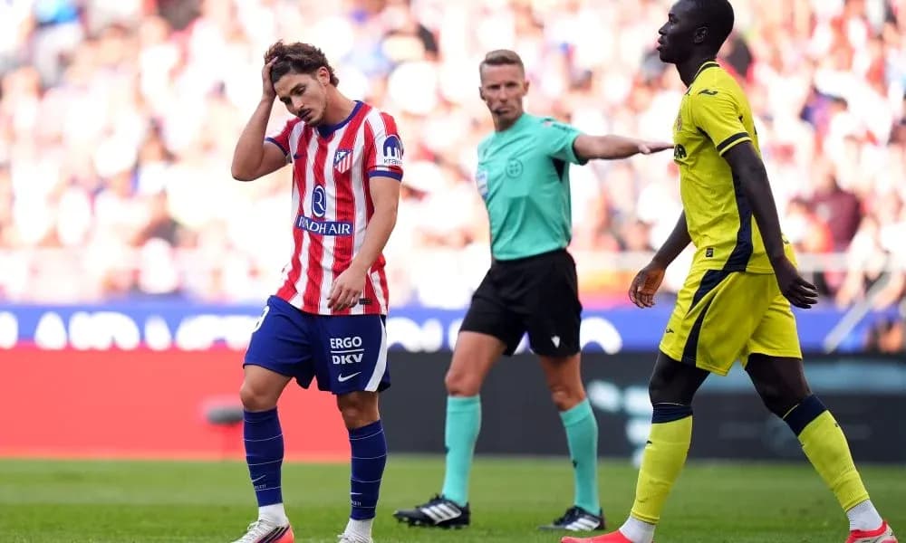 Joueur d'Atlético se tenant la tête, arbitre en arrière-plan Joueur d'Atlético se tenant la tête, arbitre en arrière-plan