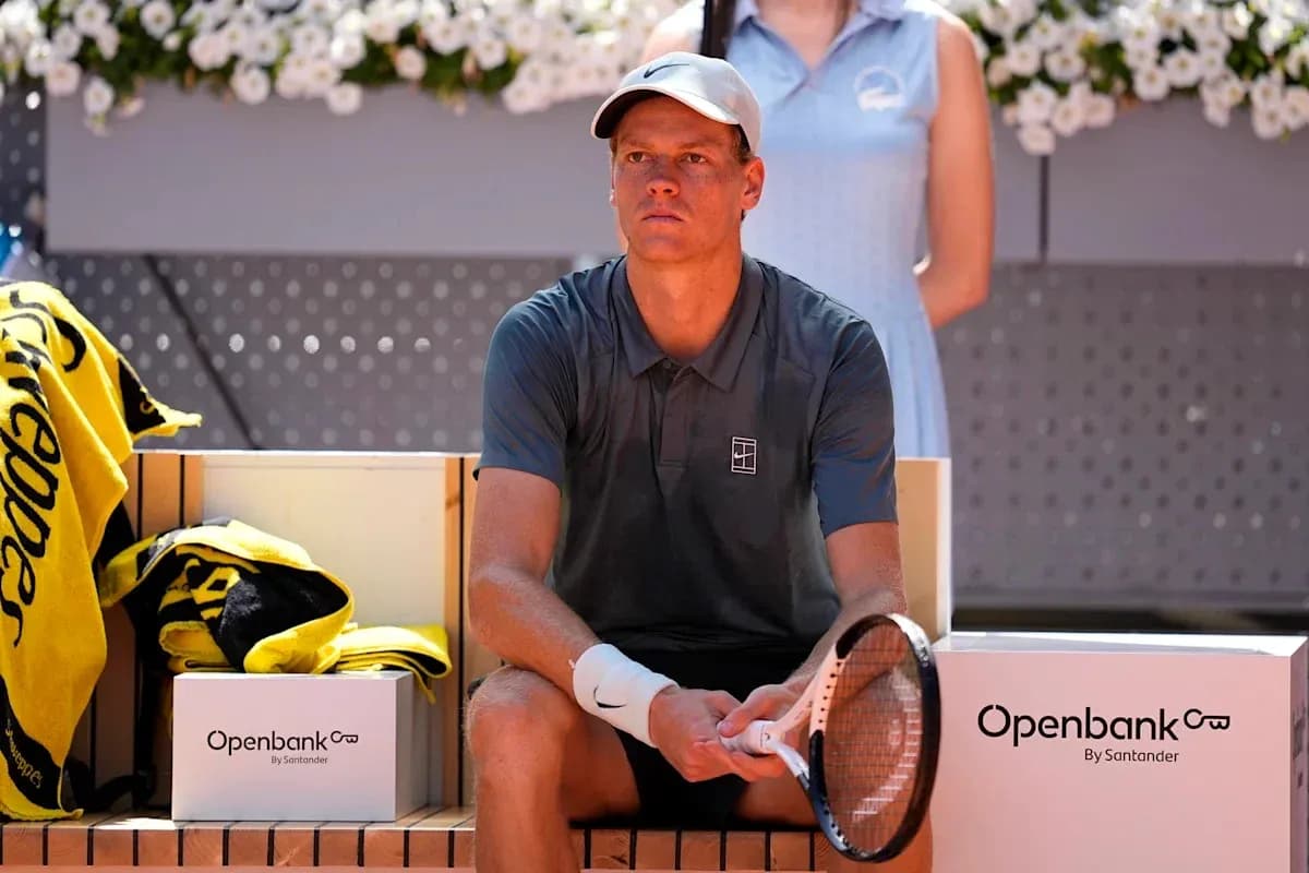 Joueur de tennis assis sur le banc, raquette en main Joueur de tennis assis sur le banc, raquette en main