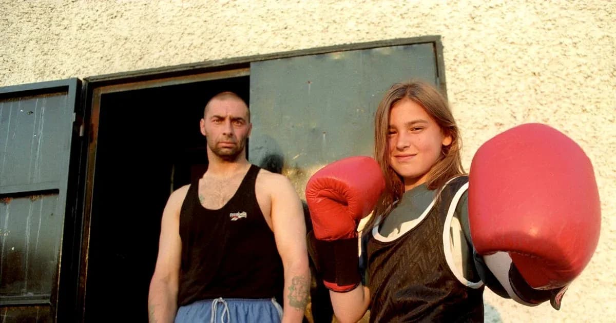 Fille avec des gants de boxe et un homme en arrière-plan Fille avec des gants de boxe et un homme en arrière-plan