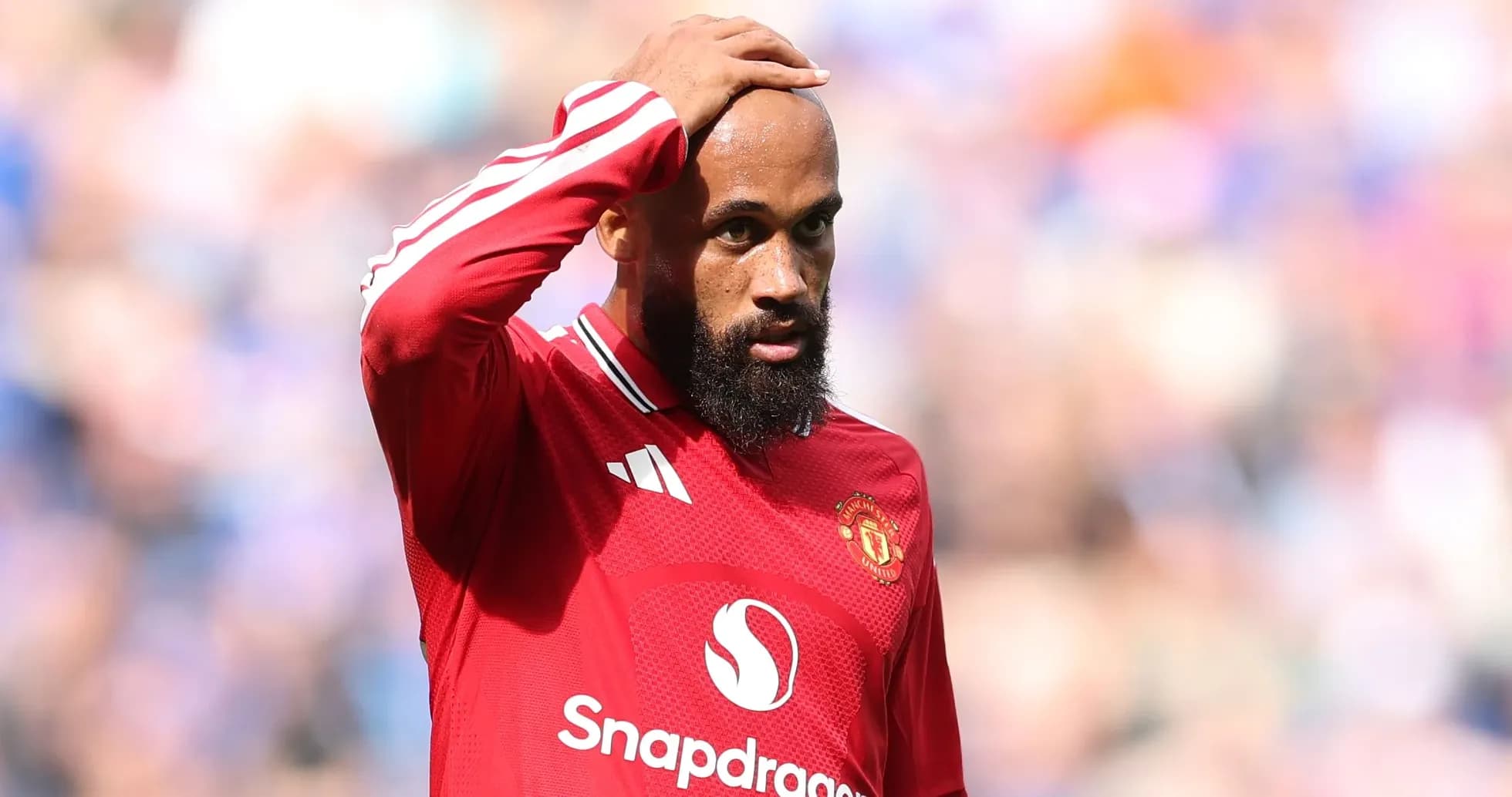 Joueur de Manchester United touchant sa tête sur le terrain Joueur de Manchester United touchant sa tête sur le terrain