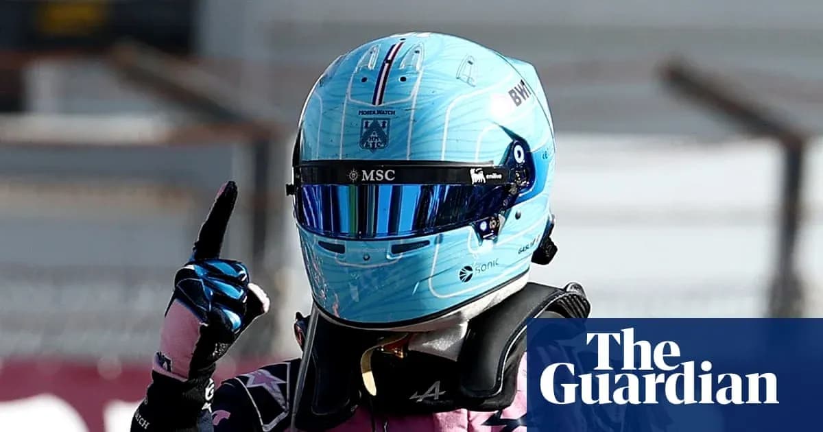 Pilote de Formule 1 portant un casque bleu levant un doigt Pilote de Formule 1 portant un casque bleu levant un doigt