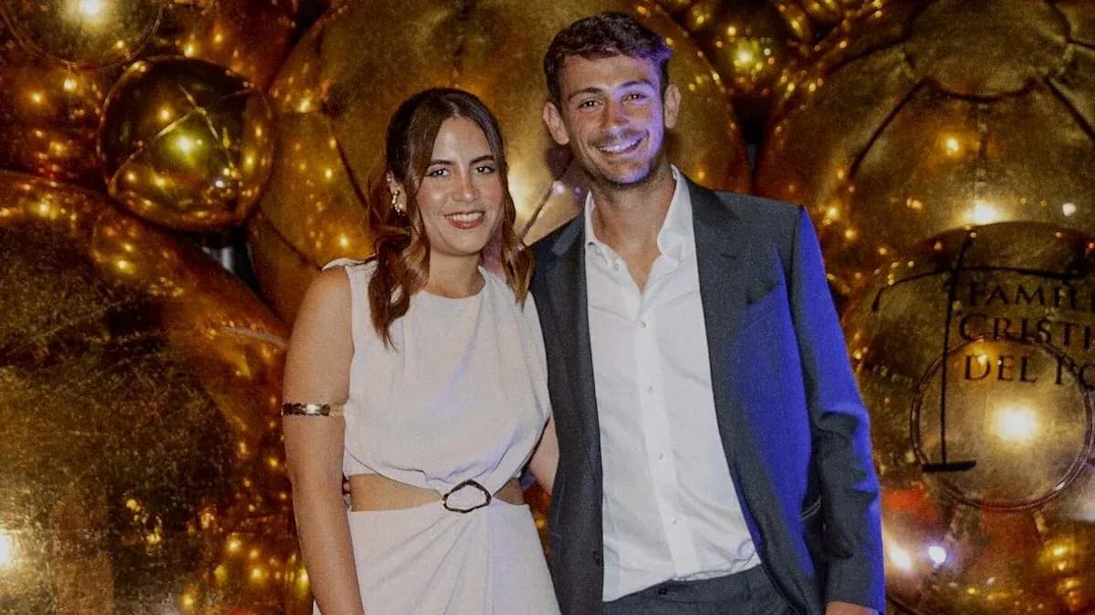 Couple posing at event with golden decorations Couple posing at event with golden decorations